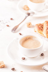 Traditional breakfast with fresh croissants on white background.