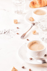 Traditional breakfast with fresh croissants on white background.
