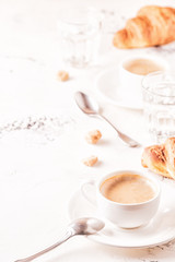 Traditional breakfast with fresh croissants on white background.