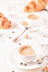 Traditional breakfast with fresh croissants on white background.