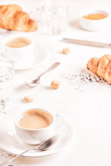 Traditional breakfast with fresh croissants on white background.