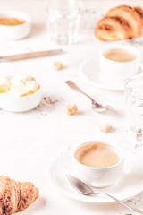 Traditional breakfast with fresh croissants on white background.