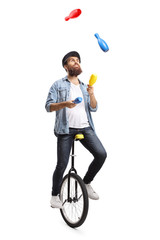 Bearded man on a unicycle juggling with clubs