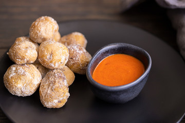 Famous Canary Islands dish, Papas Arrugadas (wrinkly potatoes with salt) and Mojo picon (red sauce) on wood table