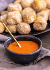 Famous Canary Islands dish, Papas Arrugadas (wrinkly potatoes with salt) and Mojo picon (red sauce) on wood table