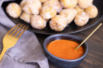 Famous Canary Islands dish, Papas Arrugadas (wrinkly potatoes with salt) and Mojo picon (red sauce) on wood table