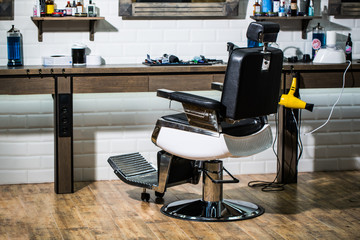 Professional hairstylist in barbershop interior. Barber shop chair. Barbershop armchair, modern hairdresser and hair salon, barber shop for men. Beard, bearded man. Stylish vintage barber chair.