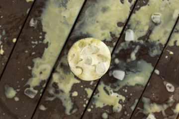 Ice cold sweet green lime tea drink on the wooden table with outdoor sun lighting with ice cubes and splashes of drink