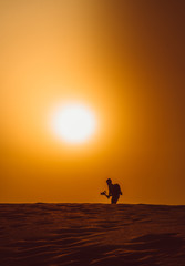 Silhouette of a man walking in the heat of the desert in a hot day