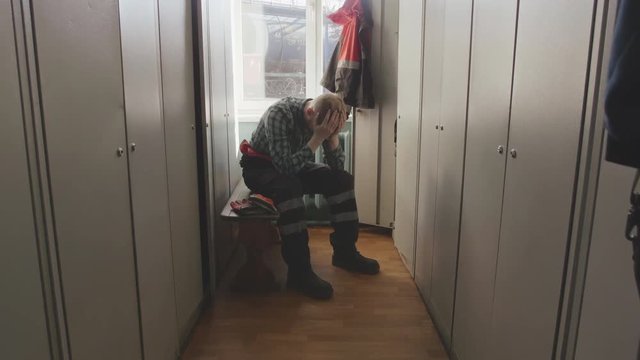 Engineer in uniform has difficulties with work, clutches head in despair