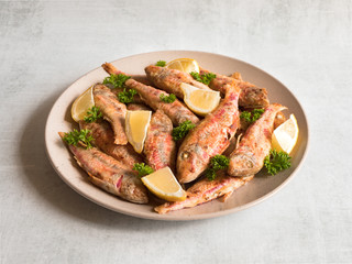 Fried fish on a plate. Dietary surmullet fish. 