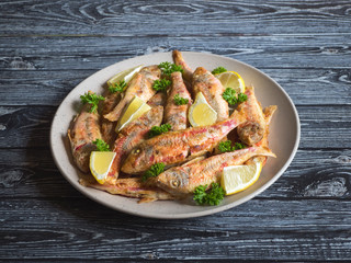 Fried fish on a plate. Dietary surmullet fish. 