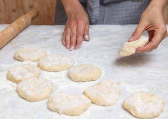 Girl rolls the dough in the kitchen