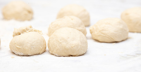 Fototapeta na wymiar Dough pieces on the table in the kitchen