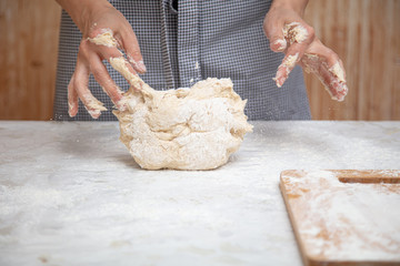 Mistress kneads the dough in the kitchen