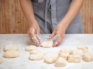 The hostess cuts the dough in the kitchen