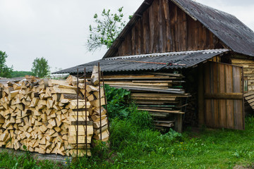 Fuel for stove heating at home and bath. Rural life. Wooden firewood is laid in the walls. Natural wood.