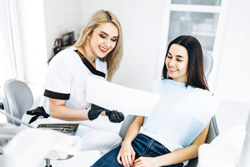 Dentist showing x-ray for the patient and explaining plan of treatment.