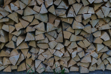 Fuel for stove heating at home and bath. Rural life. Wooden firewood is laid in the walls. Natural wood.