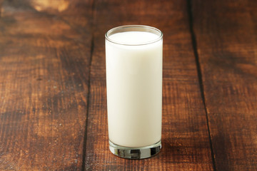 A glass with milk on a wooden rustic table