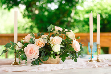 Decorated table for dinner for two person, with plates knife, fork, cheese, wine, wine glasses and flowers in a copper vase.