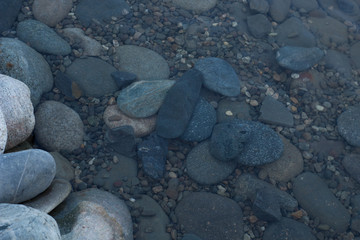 Rocks in water, wet background, summer seashore