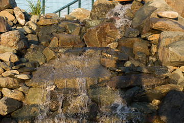 Little waterfall in the artificial park, nature in summer 