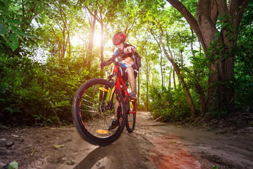 Fototapeta na wymiar Woman cyclist bicycle riding in way of the rainforest road, adventure woman riding mountain bike alone in forest at countryside