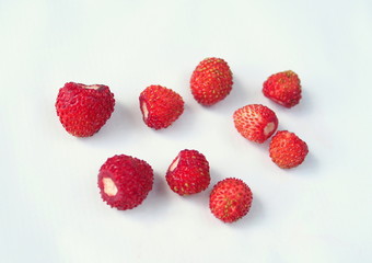 Several red ripe berries of wild strawberry on a light background