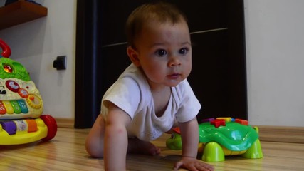 cute seven months old baby boy learning crawling, static shot