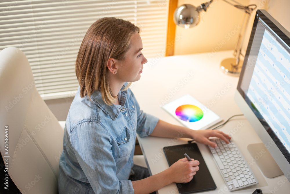 Poster graphic designer works on a computer using a graphic tablet on a table. working with web design. fre