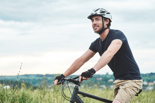 Attractive young man is cycling at the mountains. Cropped photo