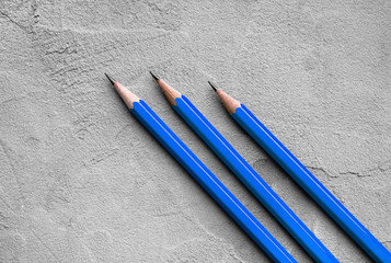 concept of business, Back to school, three sharpened pencils on a background of gray plaster...