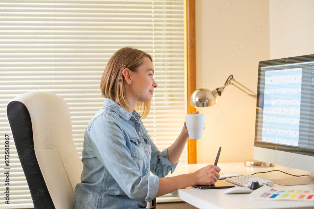 Aufkleber graphic designer works on a computer using a graphic tablet on a table. working with web design. fre