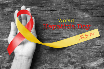 World hepatitis day awareness with red yellow ribbon  (isolated  with clipping path) on person's...