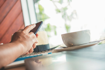 Woman typing text message on smart phone in a cafe.