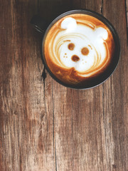 Cute dog face latte art coffee in white cup on wooden table ; cute dog latte art in your cup , love dog love coffee