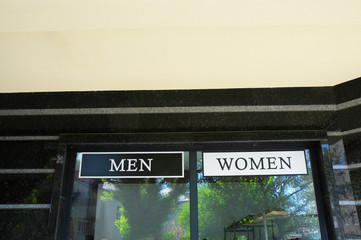 a sign for men and women in a clothing store in a big city