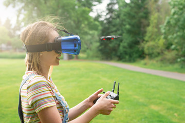 The girl controls a quadrocopter in the park with the help of a VR helmet. The concept of virtual reality. extra reality