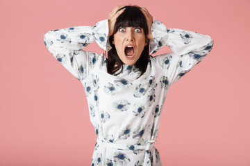 Amazing scared shocked woman posing isolated over light pink background wall.