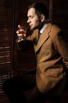 Bearded man taste alchohol drink in luxury interior