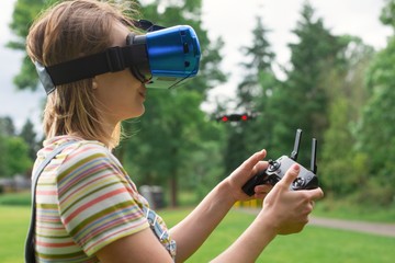 The girl controls a quadrocopter in the park with the help of a VR helmet. The concept of virtual...