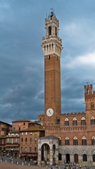 Fototapeta premium Torre del Mangia, clock tower of a city hall on Piazza del Campo main square in Siena, Tuscany, Italy