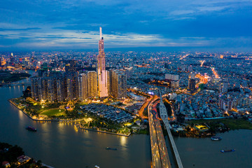 Naklejka premium Top View of Building in a City - Aerial view Skyscrapers flying by drone of Ho Chi Mi City with development buildings, transportation, energy power infrastructure. include Landmark 81 and blue sky ,