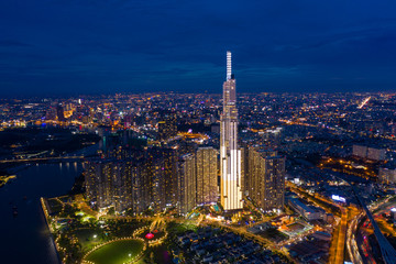 Fototapeta premium Top View of Building in a City - Aerial view Skyscrapers flying by drone of Ho Chi Mi City with development buildings, transportation, energy power infrastructure. include Landmark 81 and blue sky ,
