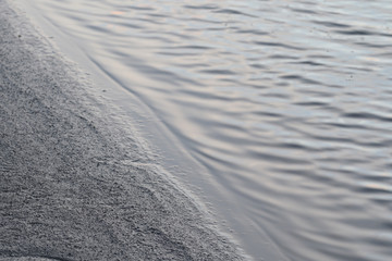 Mud flats and breaking waves Dozmary Pool Cornwall