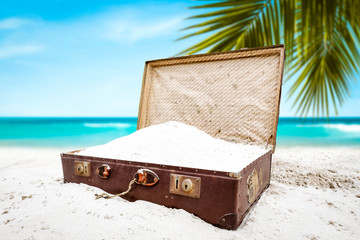 Brown retro suitcase on beach and summer time. Free space for your decoration 