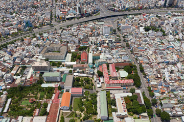 Obraz premium Top View of Building in a City - Aerial view Skyscrapers flying by drone of Ho Chi Mi City with development buildings, transportation, energy power infrastructure. include Landmark 81 and blue sky ,