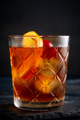 Cuba Libre with ice and citrus classic cocktail on dark wooden background