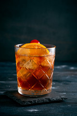 Cuba Libre with ice and citrus classic cocktail on dark wooden background